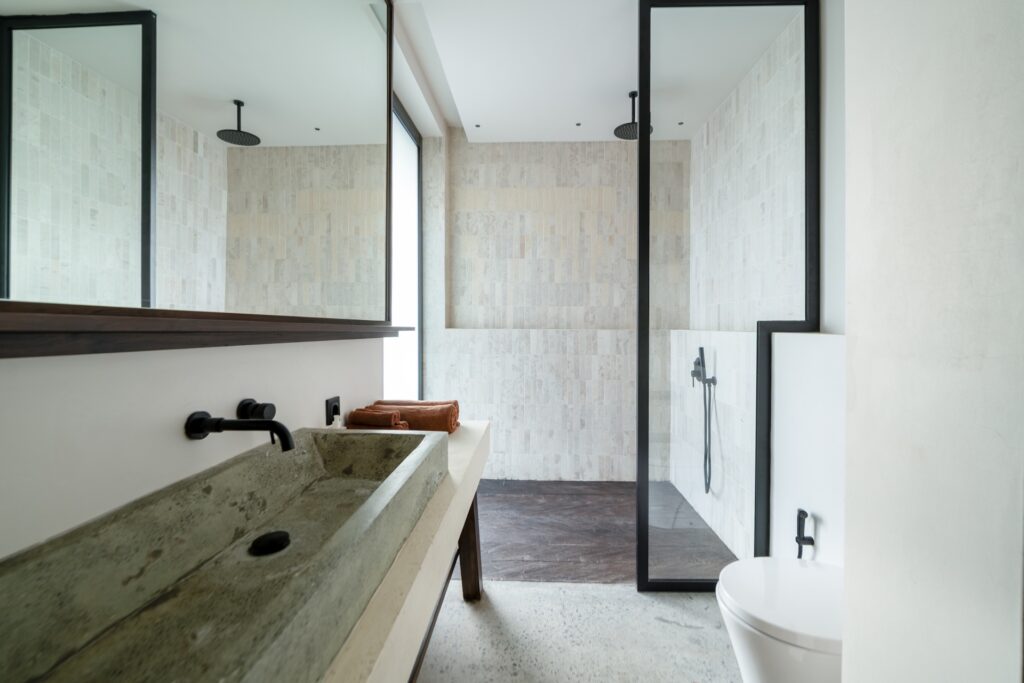 Modern en-suite bathroom at Villa Amorino in Bereban Bali with walk-in shower and stone sink